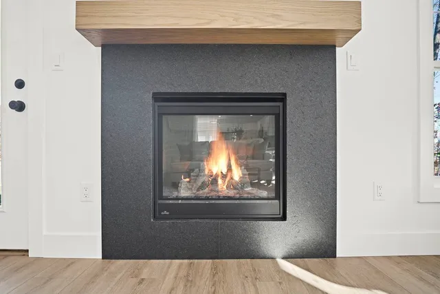 a view of a livingroom with wooden floor and a fireplace