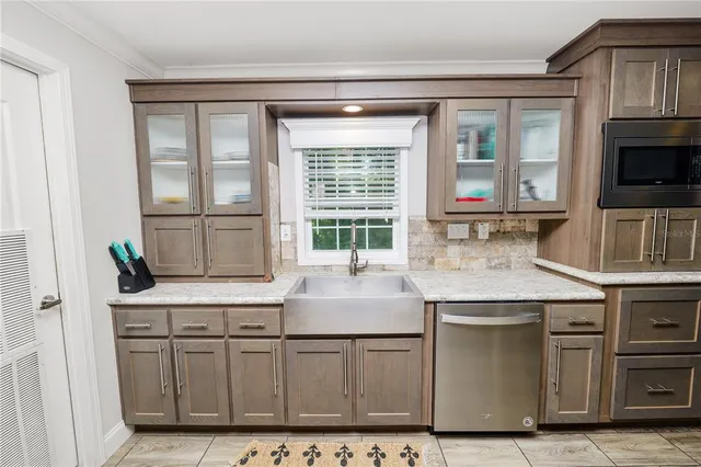 a kitchen with a sink a counter space cabinets and appliances