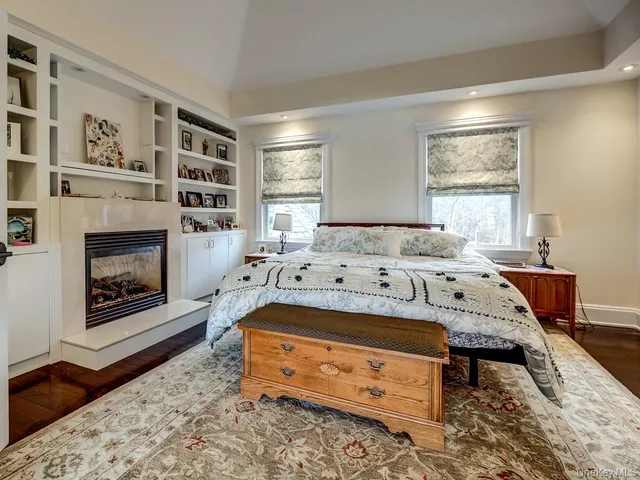 a bedroom with a bed a fireplace and windows
