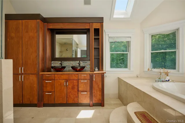 a bathroom with a tub sink and mirror