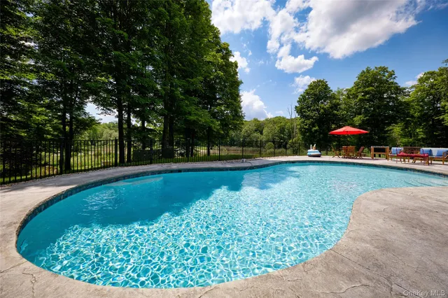 a view of a swimming pool with an outdoor seating and a yard