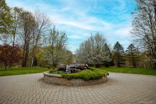 a front view of a house with a garden and trees
