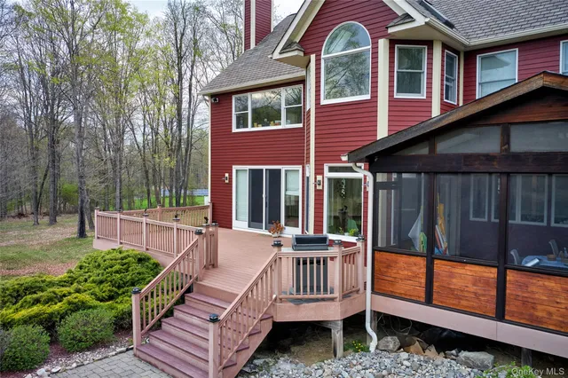 a view of a house with a wooden deck and a yard