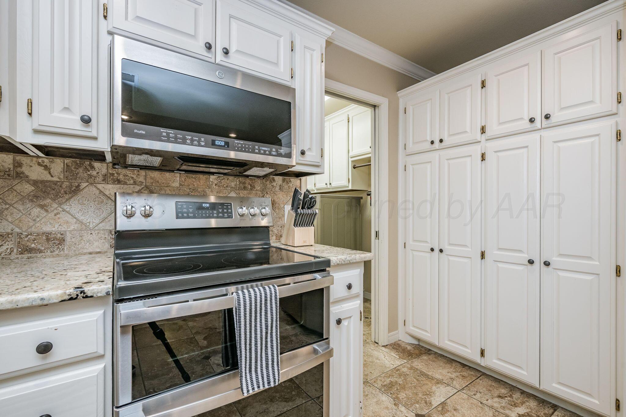 15812 Outback Trail Amarillo, TX 79118 - Photo 14 of 25 a kitchen with white cabinets and stainless steel appliances