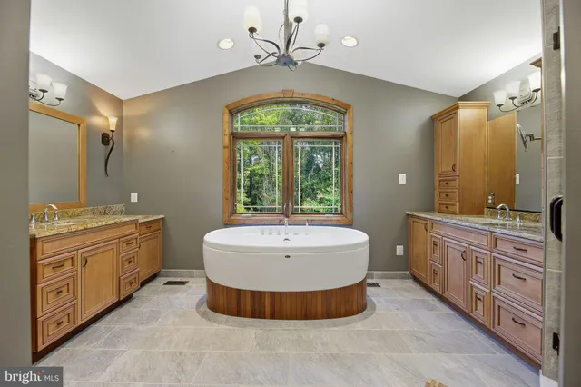 a spacious bathroom with a double vanity sink a large mirror and a bathtub