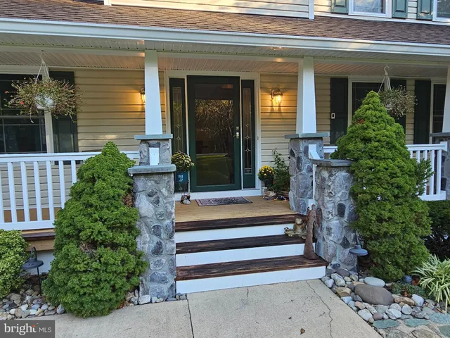 a kitchen with stainless steel appliances granite countertop a refrigerator a sink dishwasher a stove and white countertops with wooden floor