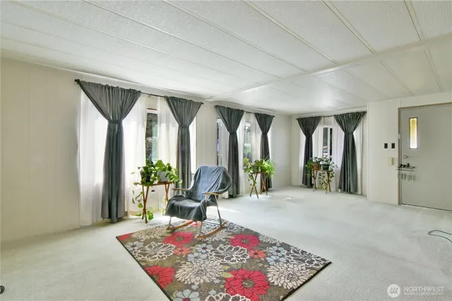 a large room with large windows and a rug