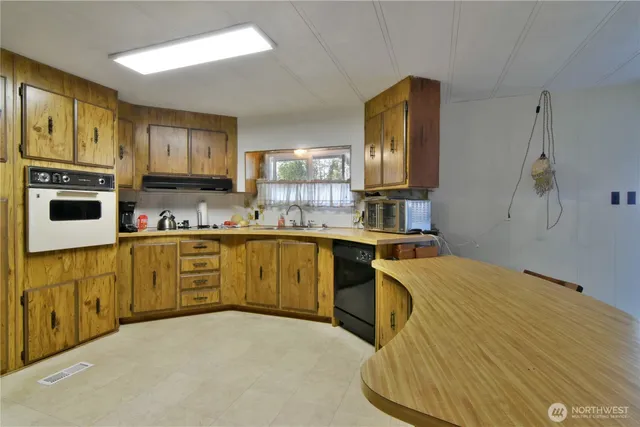 a kitchen with stainless steel appliances granite countertop a stove sink and cabinets