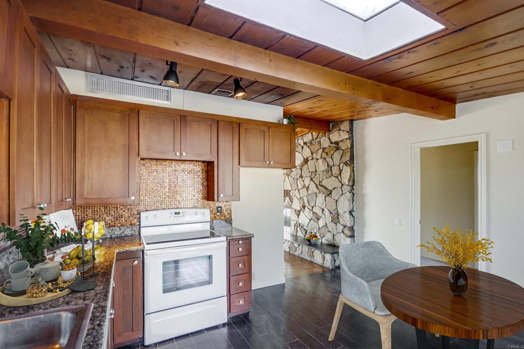 9913 Lindo Lane Lakeside, CA 92040 - Photo 5 of 53 a kitchen with stainless steel appliances kitchen island granite countertop a table chairs in it and wooden floors