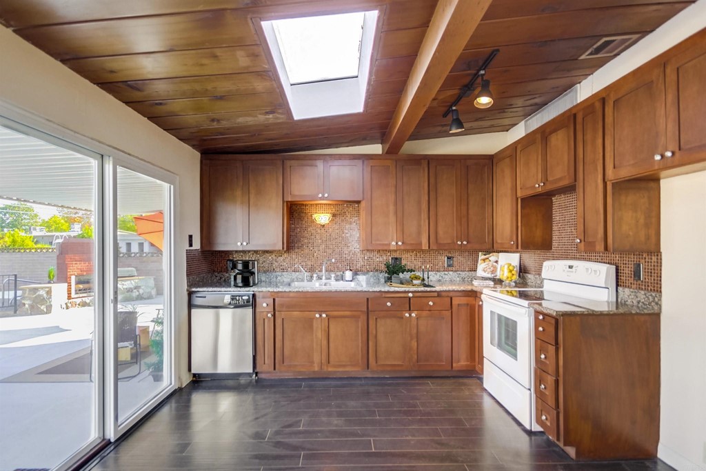 9913 Lindo Lane Lakeside, CA 92040 - Photo 6 of 53 a kitchen with stainless steel appliances a stove a refrigerator a sink and white cabinets with wooden floor