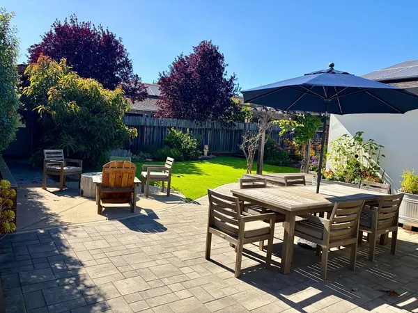 a view of backyard with seating space and trees