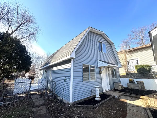 a view of a small house with a yard