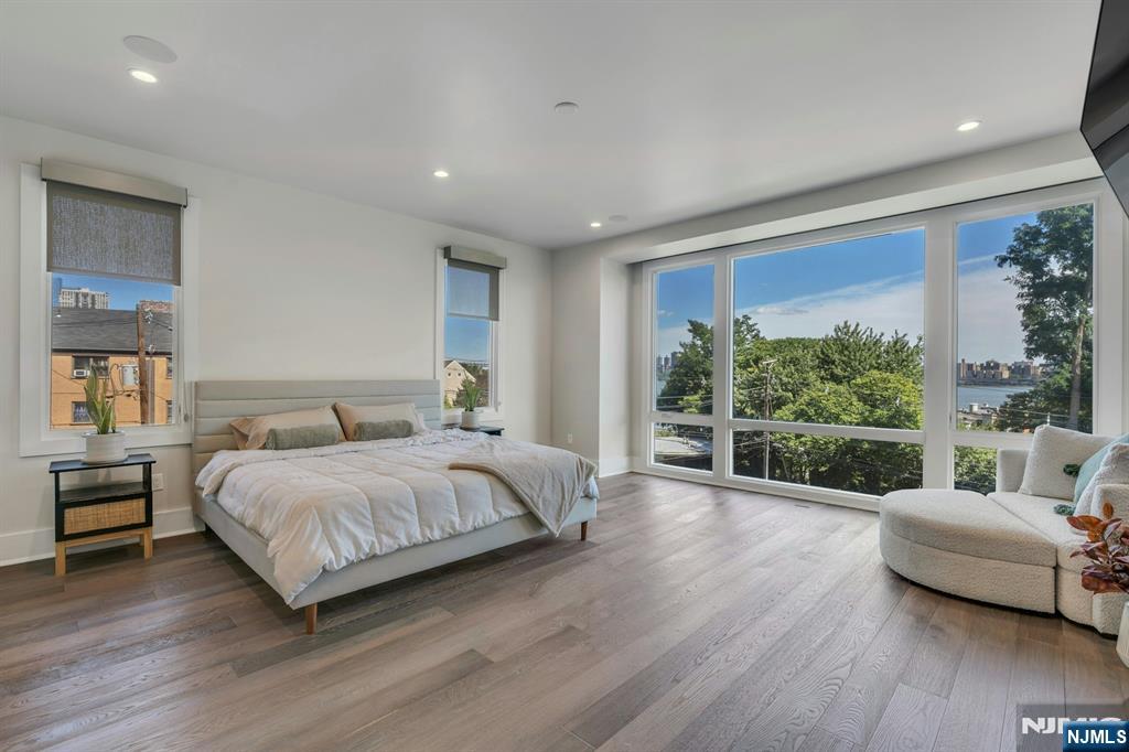 1238 River Road Edgewater, NJ 07020 - Photo 14 of 45 a spacious bedroom with a bed and a couch