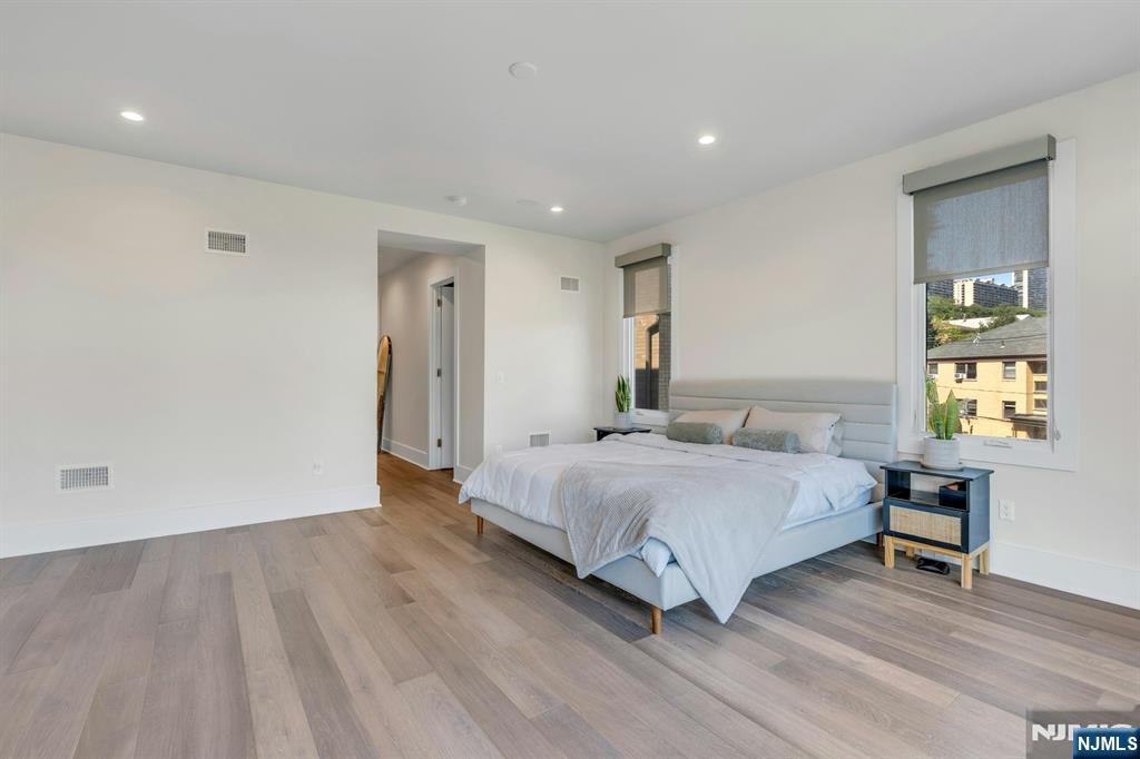 1238 River Road Edgewater, NJ 07020 - Photo 16 of 45 a spacious bedroom with a bed and a table in it