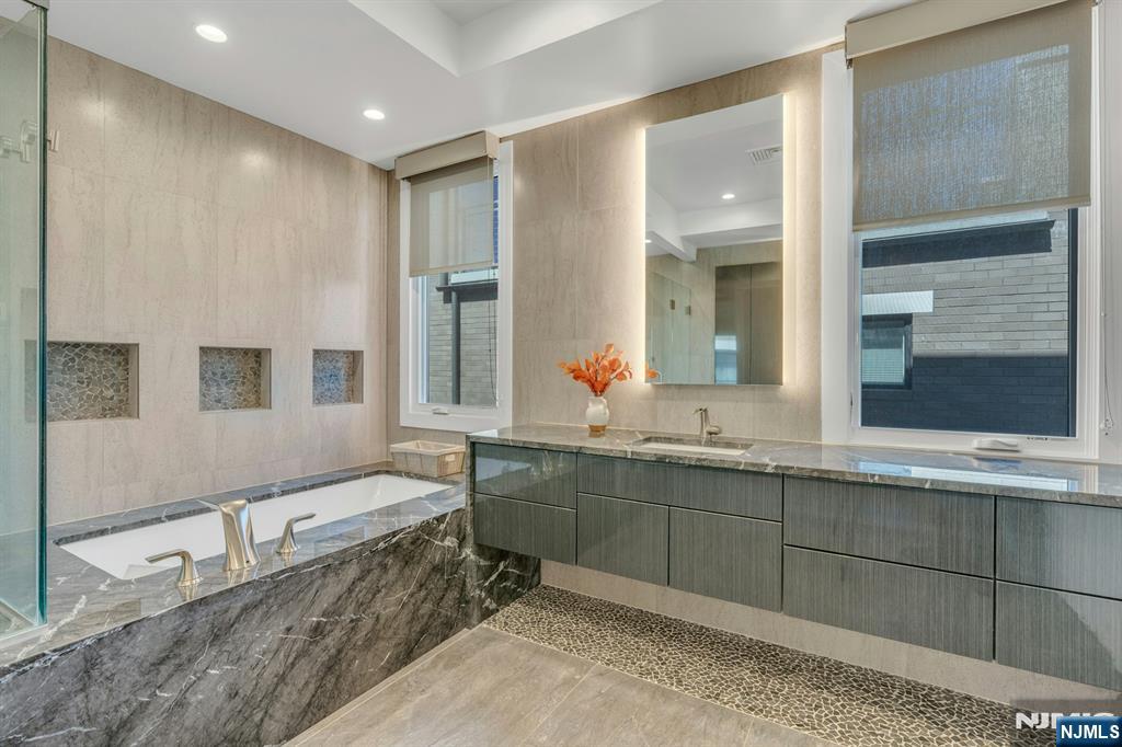 1238 River Road Edgewater, NJ 07020 - Photo 18 of 45 a spacious bathroom with a tub sink and mirror