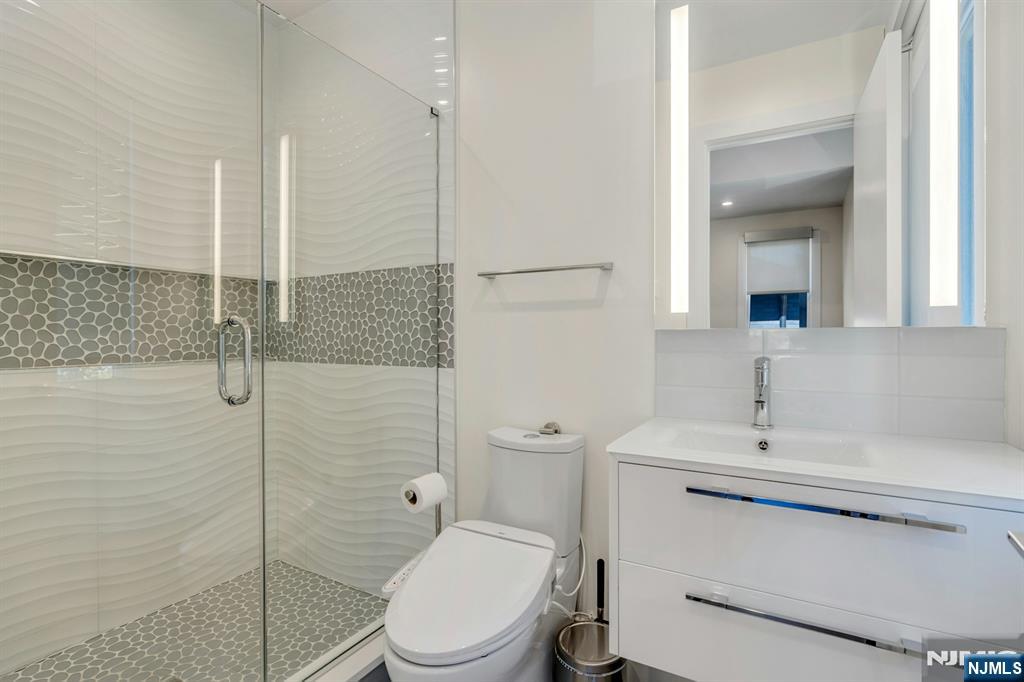 1238 River Road Edgewater, NJ 07020 - Photo 22 of 45 a bathroom with a toilet a sink and shower