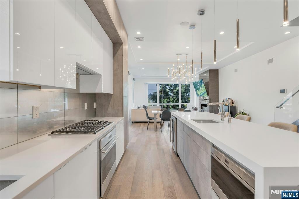 1238 River Road Edgewater, NJ 07020 - Photo 4 of 45 a kitchen with a sink a counter top space a stove and a refrigerator with wooden floor
