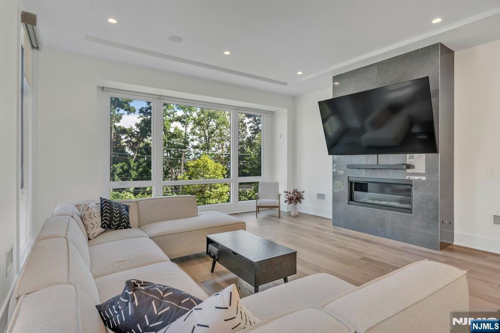 1238 River Road Edgewater, NJ 07020 - Photo 10 of 45 a living room with furniture a flat screen tv and a fireplace