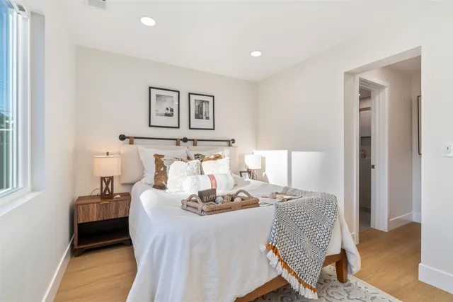 a bedroom with a bed and wooden floor