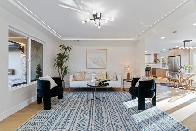 a living room with furniture a rug a lamp and a window