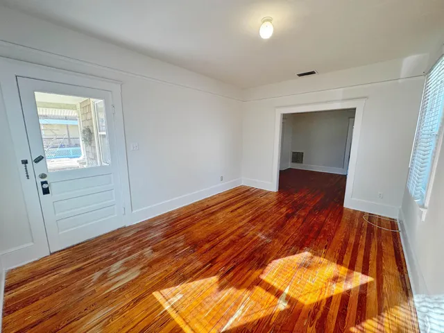 a view of a room with wooden floor