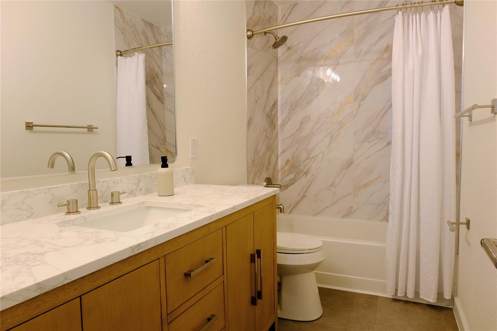 3437 Caprock Ranch Road Fort Worth, TX 76262 - Photo 16 of 27 a bathroom with a granite countertop sink toilet and shower