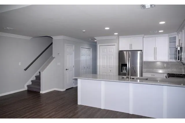 a kitchen with kitchen island a counter top space cabinets and stainless steel appliances