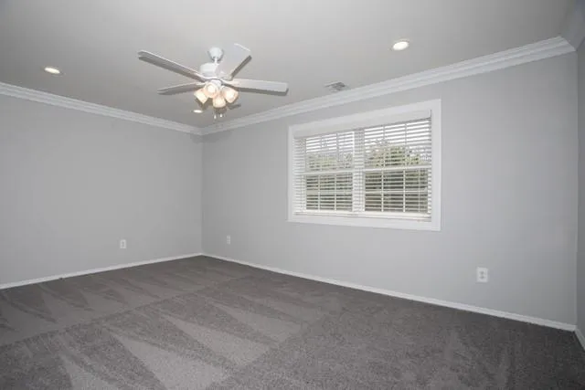 an empty room with window and ceiling fan
