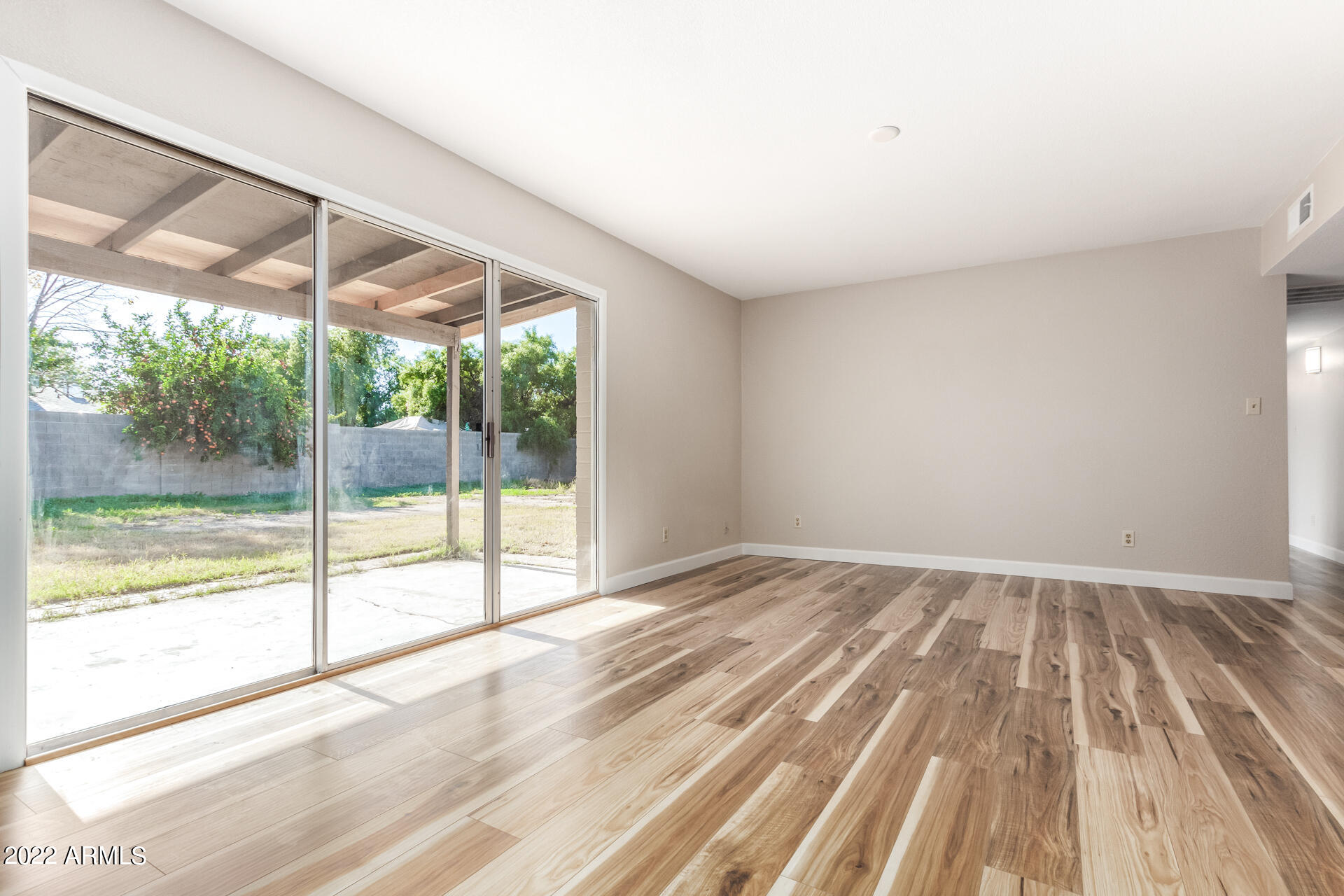 1225 West Halstead Drive Phoenix, AZ 85023 - Photo 6 of 19 a view of an empty room with wooden floor and a window