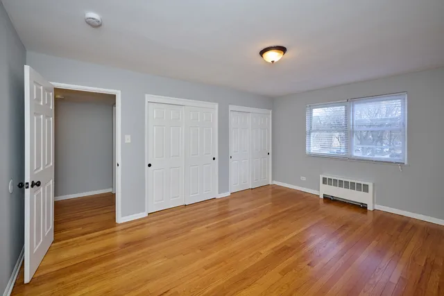 a view of a room with wooden floor and a window