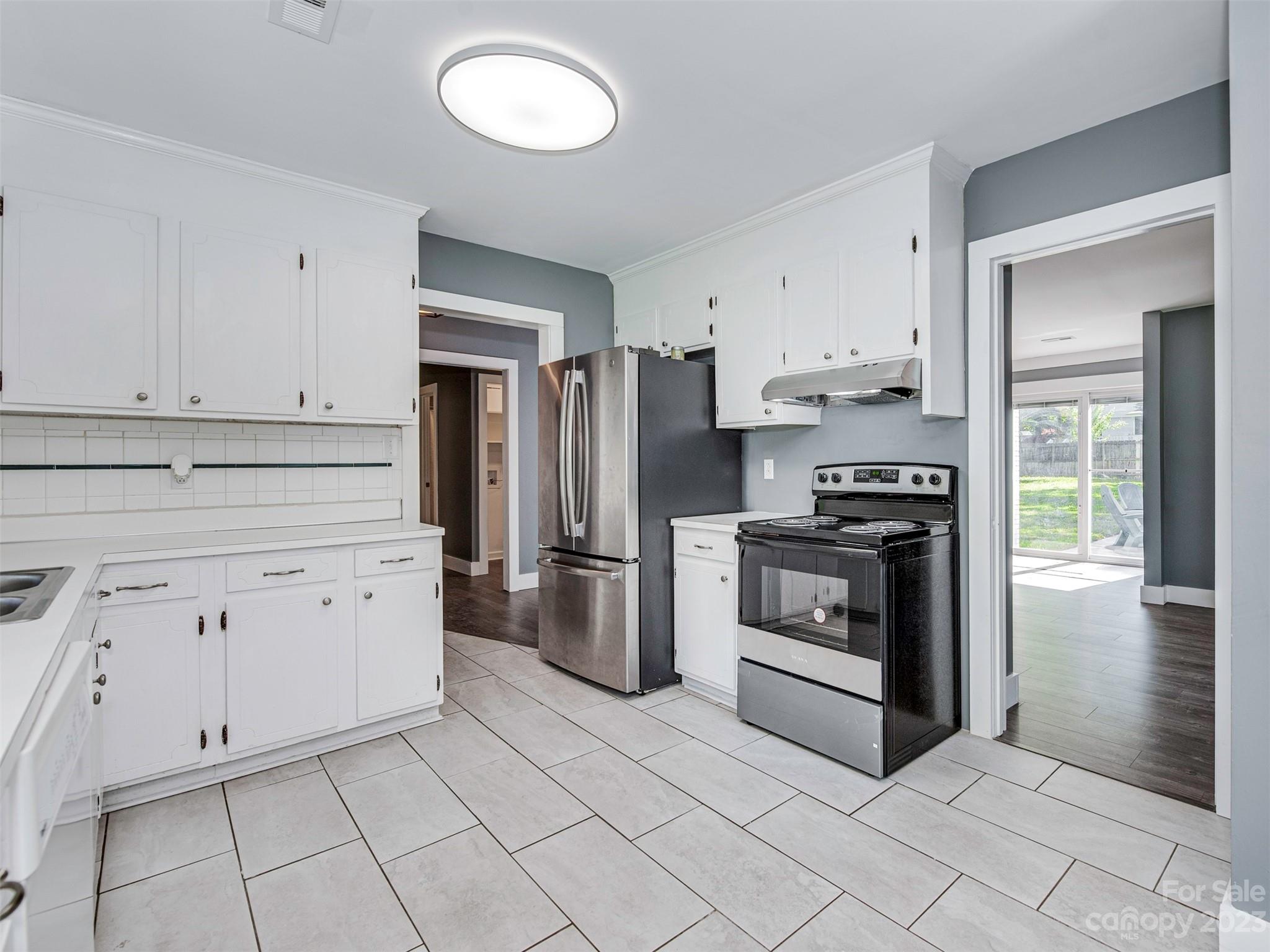 9613 Watergate Road Charlotte, NC 28270 - Photo 8 of 33 a kitchen with white cabinets and stainless steel appliances