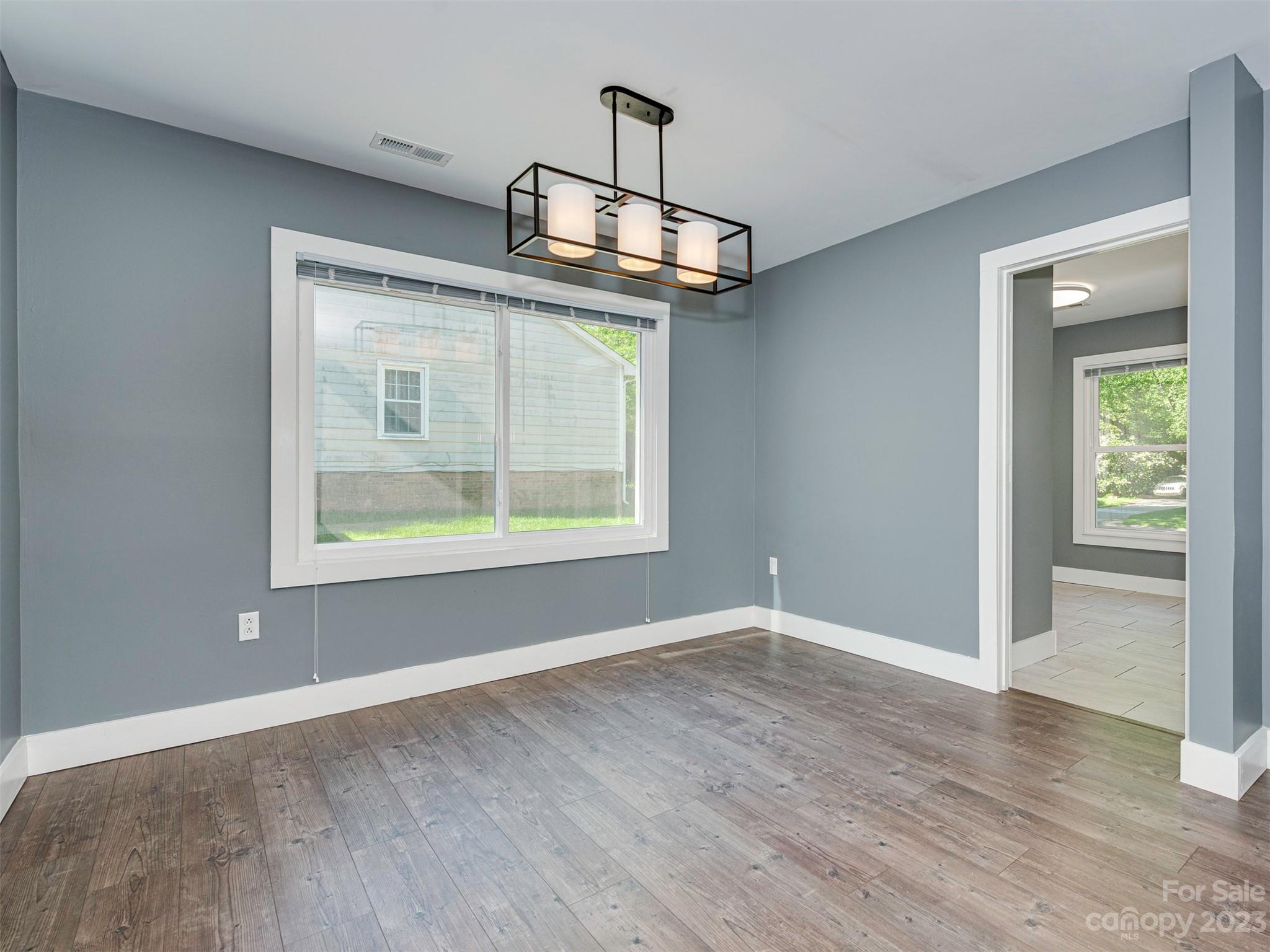 9613 Watergate Road Charlotte, NC 28270 - Photo 9 of 33 an empty room with wooden floor cabinet and windows