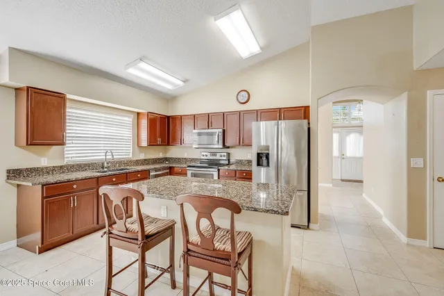a kitchen with granite countertop stainless steel appliances a refrigerator a stove a sink dishwasher and cabinets