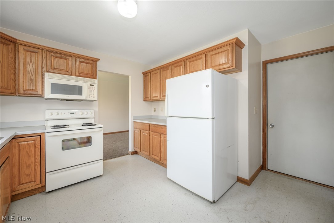 8464-8446 Tallmadge Road Diamond, OH 44412 - Photo 11 of 39 Kitchen featuring light flooring, white appliances, light countertops, and wood finish cabinets