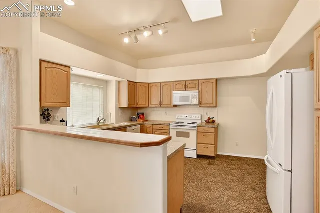 a kitchen with appliances a sink a counter top space and cabinets