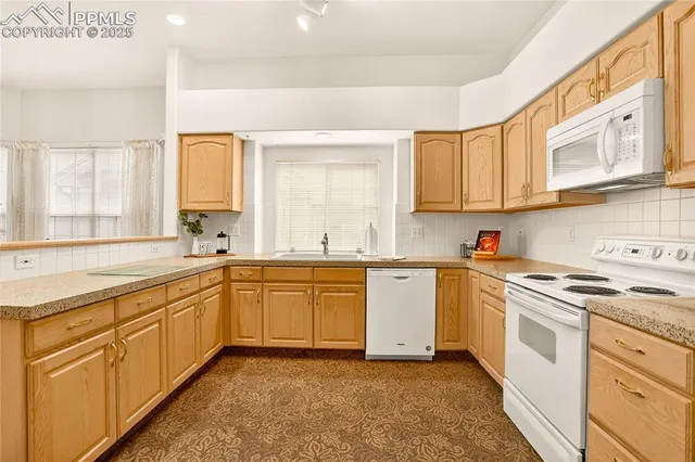 a kitchen with granite countertop white cabinets and white appliances