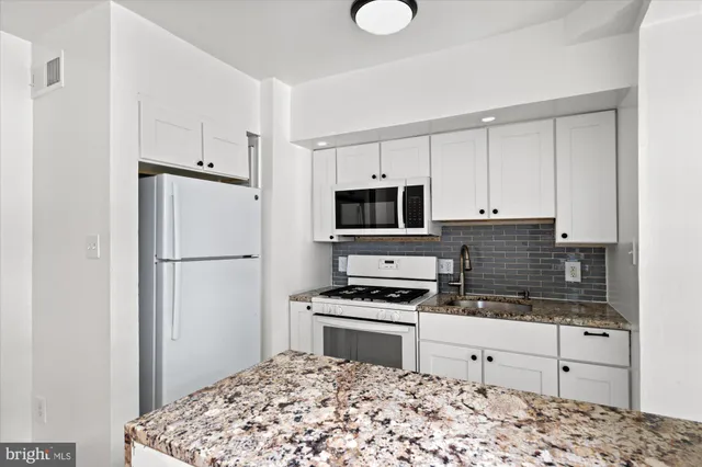a kitchen with stainless steel appliances a refrigerator stove and microwave