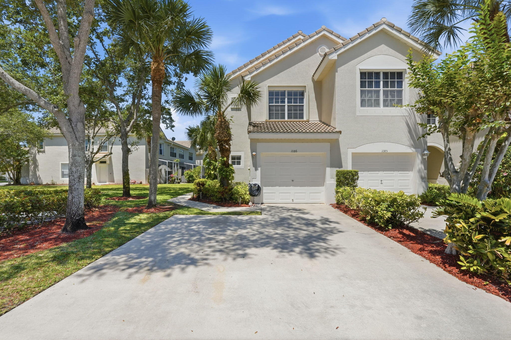 1086 Woodfield Road Greenacres, FL 33415 - Photo 1 of 32 a front view of a house with a yard and garage