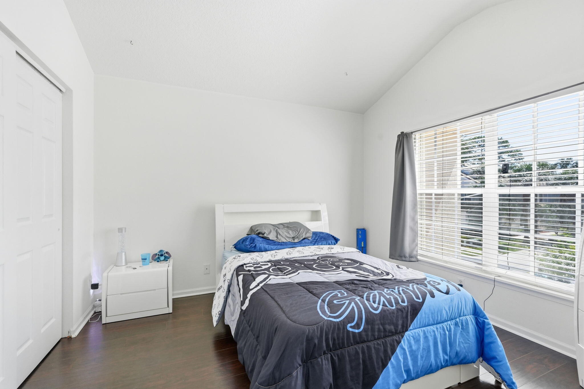 1086 Woodfield Road Greenacres, FL 33415 - Photo 20 of 32 a bed sitting in a bedroom next to a window