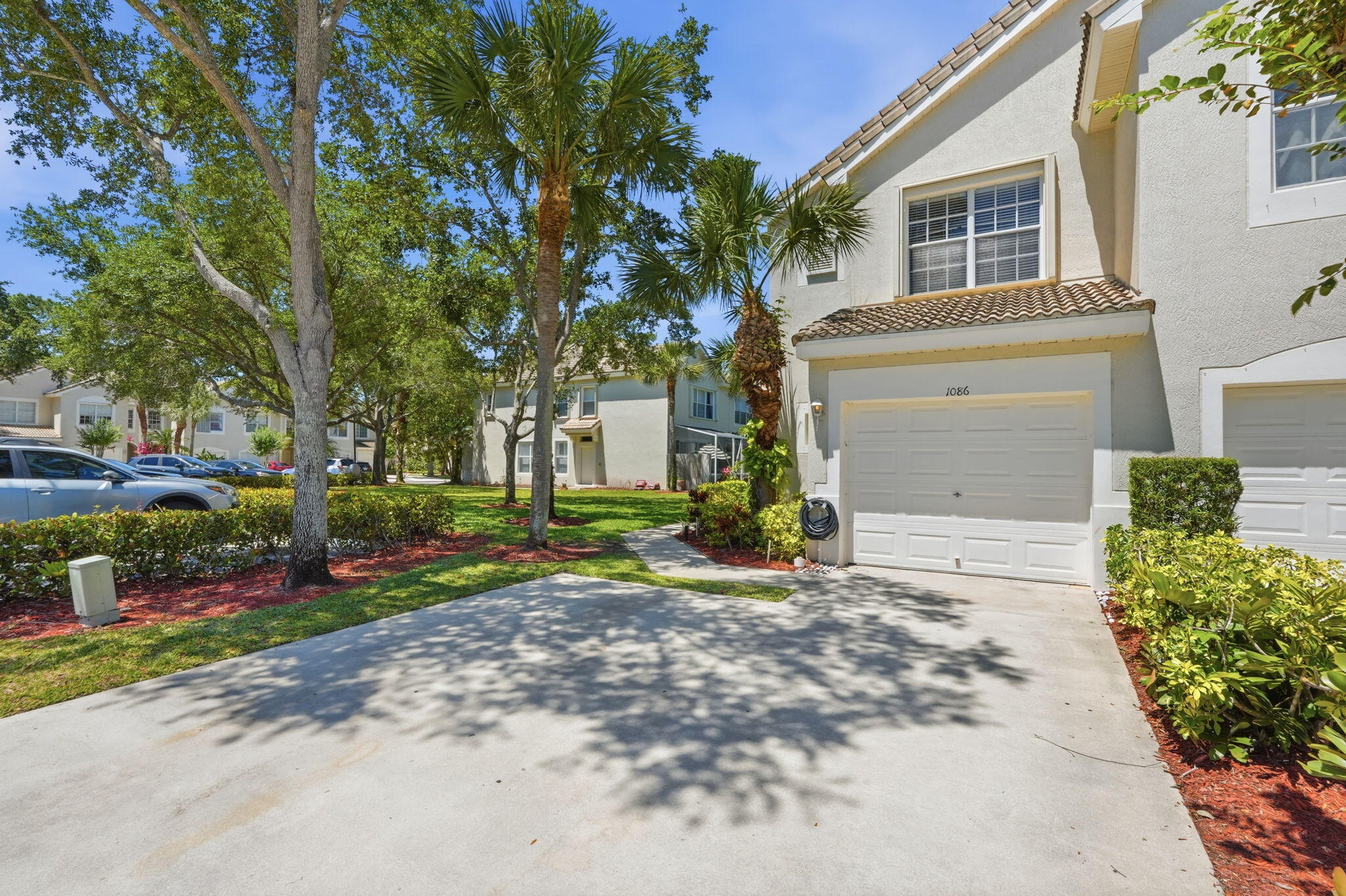 1086 Woodfield Road Greenacres, FL 33415 - Photo 2 of 32 a front view of a house with a yard and garage