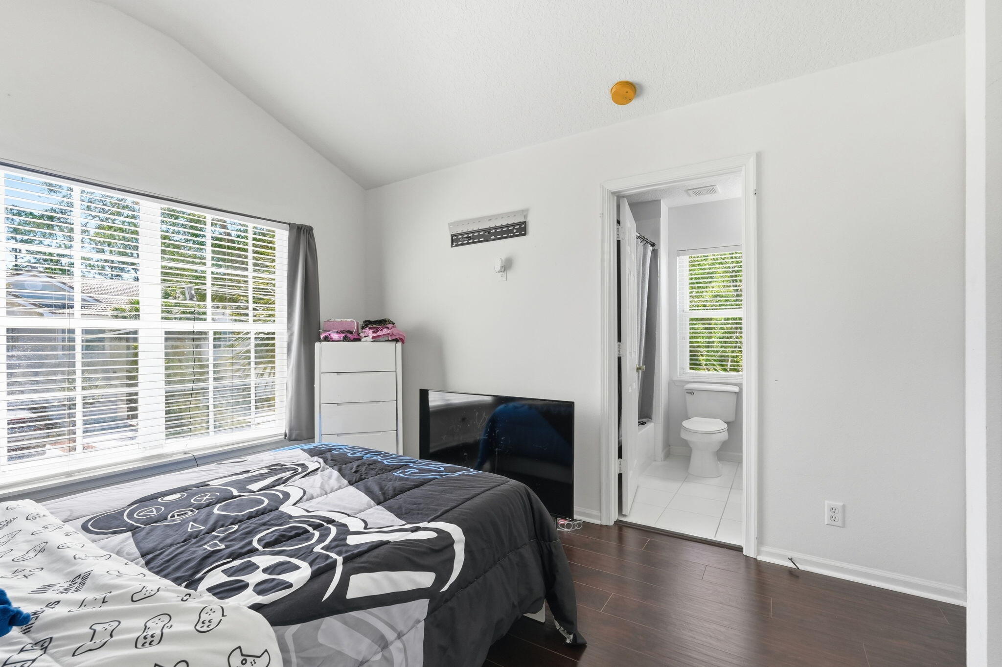 1086 Woodfield Road Greenacres, FL 33415 - Photo 21 of 32 a bedroom with a bed and wooden floor