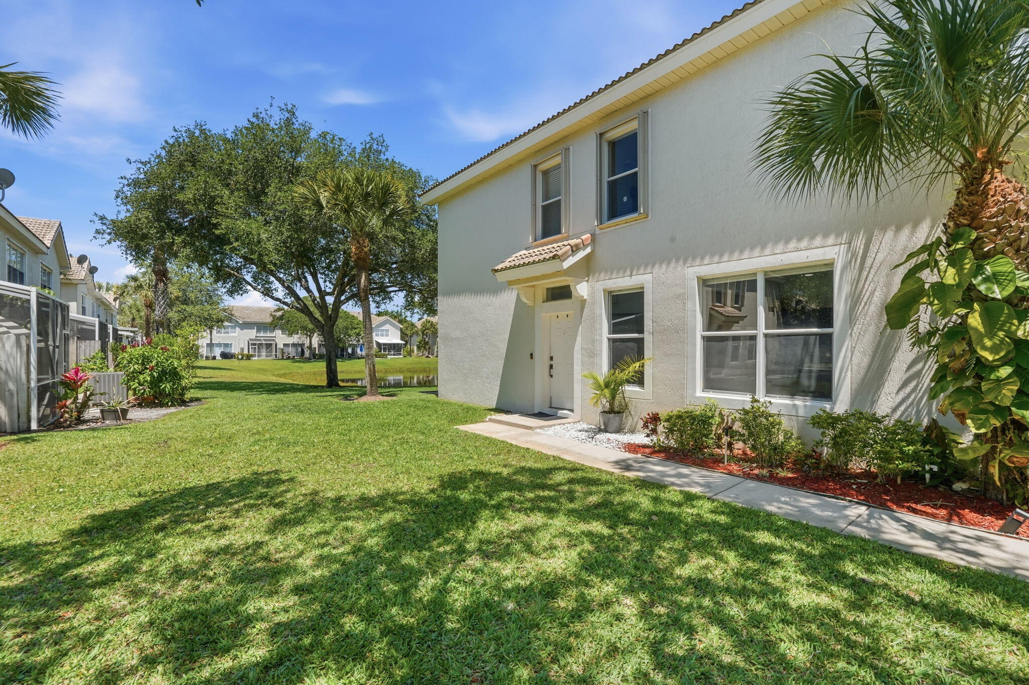 1086 Woodfield Road Greenacres, FL 33415 - Photo 3 of 32 a front view of a house with garden
