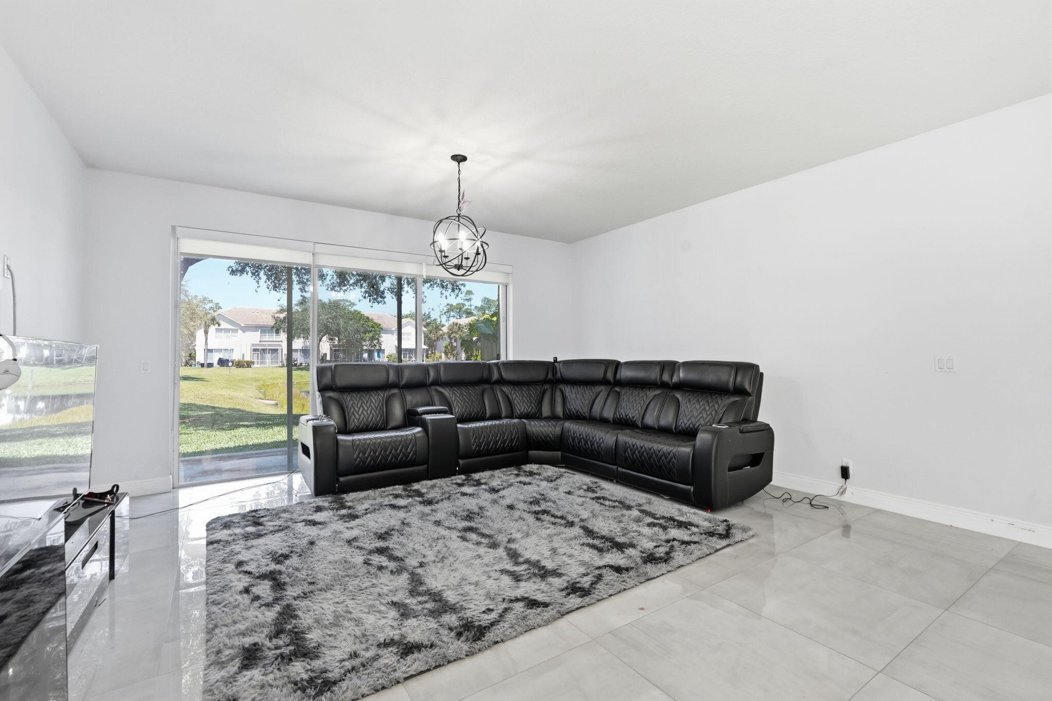 1086 Woodfield Road Greenacres, FL 33415 - Photo 4 of 32 a living room with furniture and a large window or chandelier