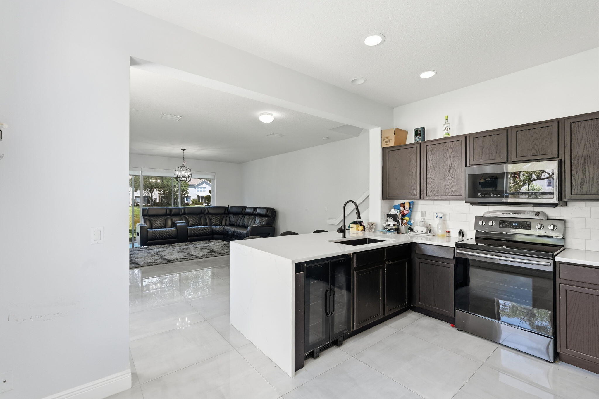 1086 Woodfield Road Greenacres, FL 33415 - Photo 10 of 32 a kitchen with stainless steel appliances a sink stove and cabinets