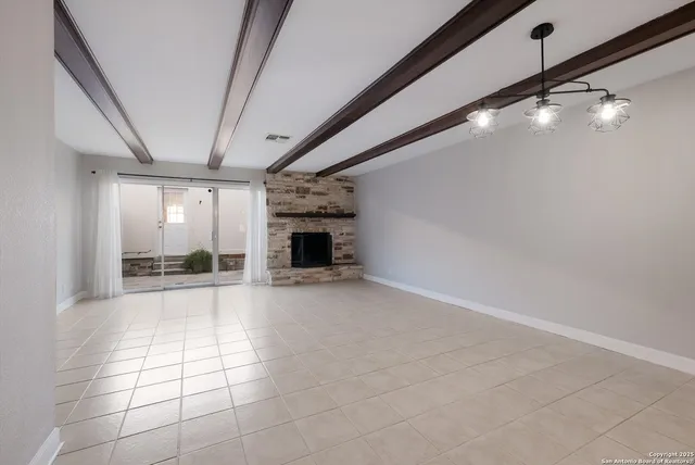 a view of an empty room with a fireplace and a window