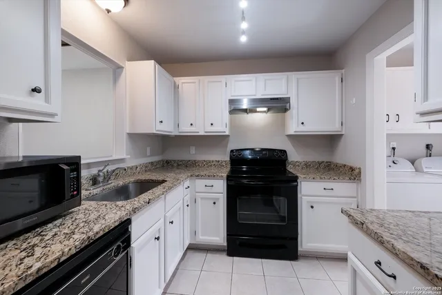 a kitchen with cabinets appliances a sink and a stove