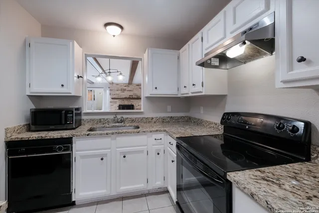 a kitchen with granite countertop a refrigerator and a stove