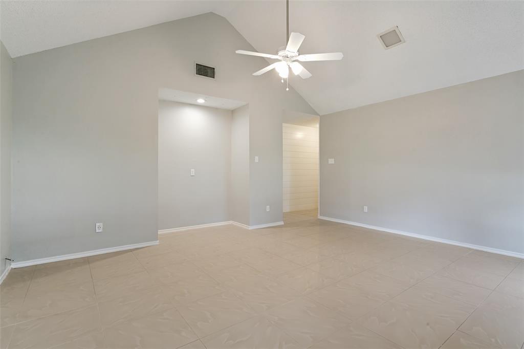 1712 East Peters Colony Road Carrollton, TX 75007 - Photo 13 of 25 Vaulted ceilings with a ceiling fan, recessed lighting in a wall niche, light gray wall paint, white baseboards, and ceramic tile flooring