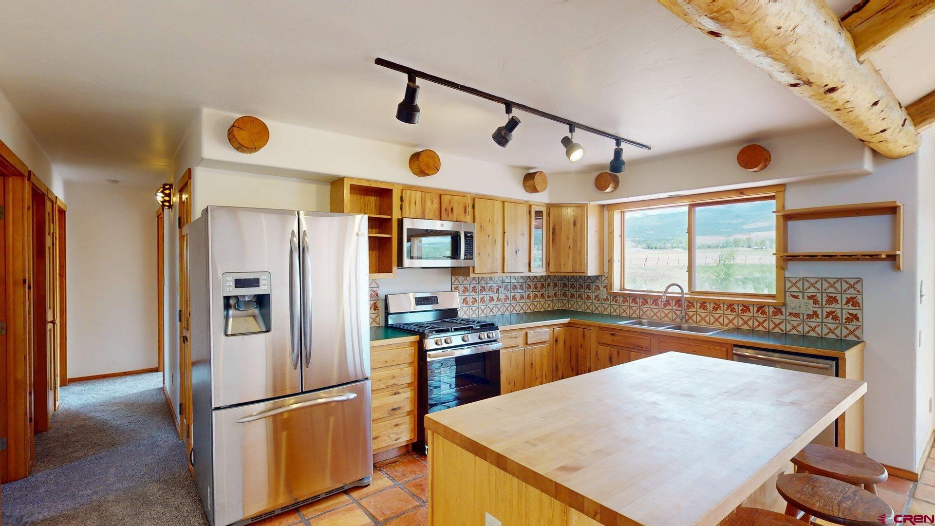 40557 M75 Road Paonia, CO 81428 - Photo 6 of 34 a kitchen with stainless steel appliances granite countertop a refrigerator a oven and white cabinets with wooden floors