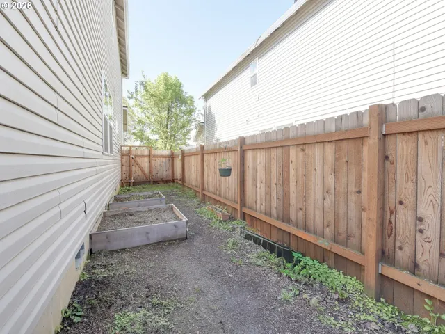 a view of a yard with wooden fence